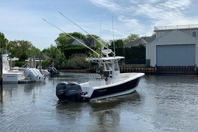 Slide: The Image of 2006 Regulator 24 Classic boat with dual engines in a serene marina setting. - 76