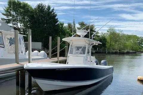 Slide: The Image of 2006 Regulator 24 Classic boat docked on a calm river under a blue sky. - 78
