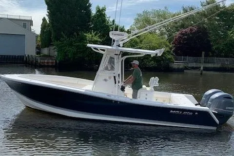 Slide: The Image of 2006 Regulator 24 Classic boat on calm water with a person at the helm. - 8