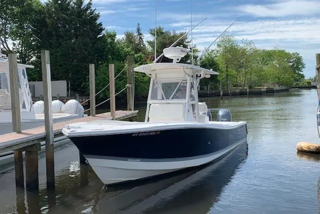 Slide: The Image of 2006 Regulator 24 Classic boat docked in a serene marina setting. - 80