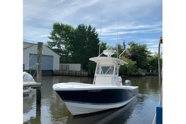 Slide: The Image of 2006 Regulator 24 Classic boat docked on a calm waterway, surrounded by trees. - 83