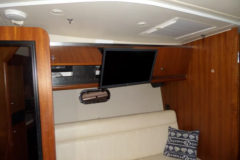 Slide: The Image of Interior of 2006 Tiara Yachts 3600 Sovran with TV, wood paneling, and cushioned seating. - 23