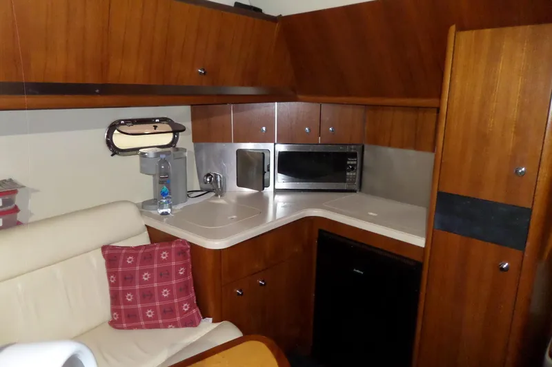 Slide: The Image of 2006 Tiara Yachts 3600 Sovran interior kitchen with microwave, sink, and wooden cabinetry. - 31