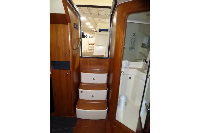 Slide: The Image of Interior view of 2006 Tiara Yachts 3600 Sovran, featuring wooden stairs and compact bathroom. - 32