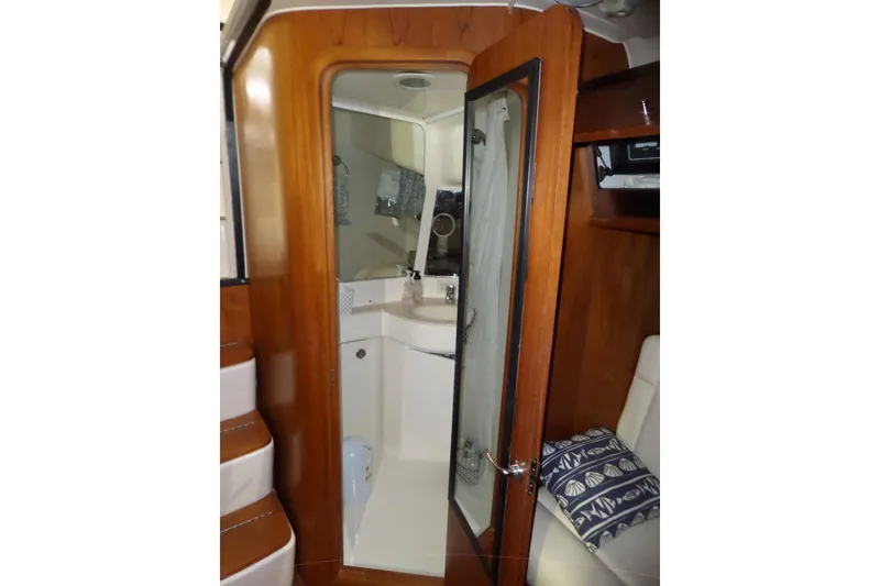 Slide: The Image of 2006 Tiara Yachts 3600 Sovran interior with wooden cabinetry and compact bathroom. - 33