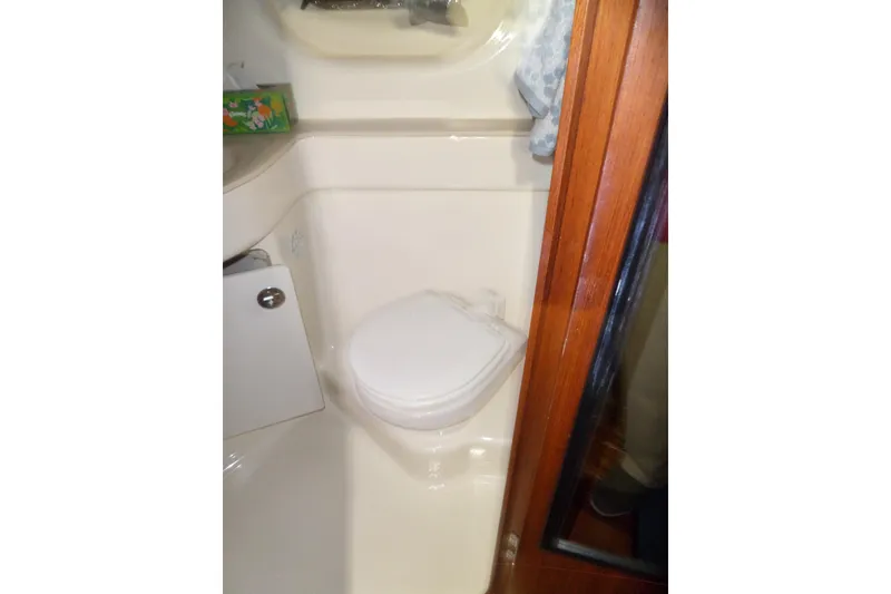 Slide: The Image of Bathroom interior of 2006 Tiara Yachts 3600 Sovran, featuring compact toilet and wooden door. - 35