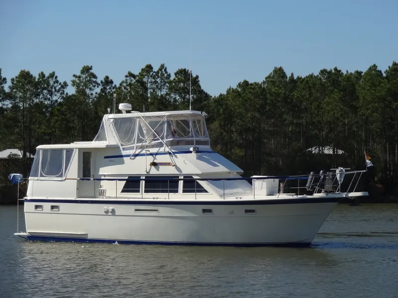 The Image of 1987 Hatteras 43 yacht on calm water with trees in background. - 0