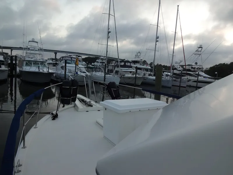 Slide: The Image of 1987 Hatteras 43 yacht docked in marina under cloudy sky. - 26