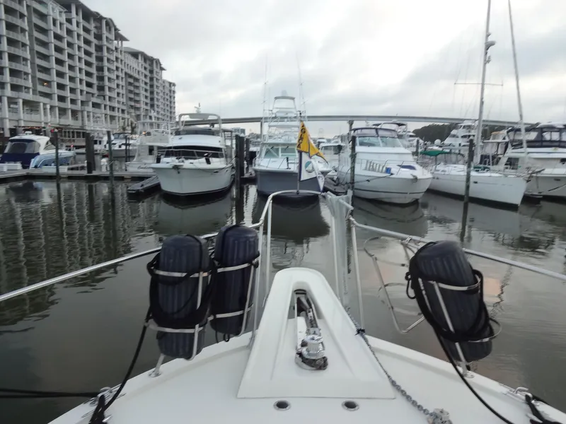 Slide: The Image of 1987 Hatteras 43 yacht docked among other boats in marina. - 27