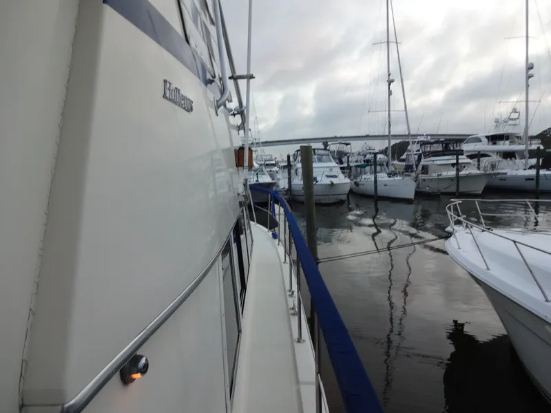 Slide: The Image of 1987 Hatteras 43 yacht docked in marina, surrounded by boats. - 31