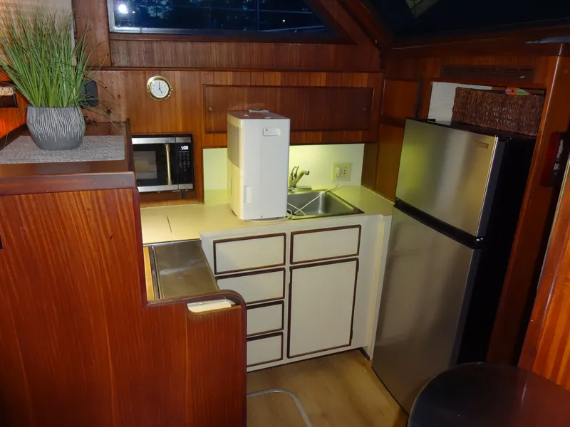 Slide: The Image of Compact kitchen on a 1987 Hatteras 43 yacht with wood paneling. - 45