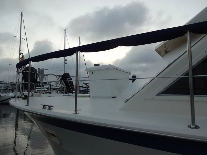 Slide: The Image of 1987 Hatteras 43 yacht docked in harbor under cloudy sky. - 5