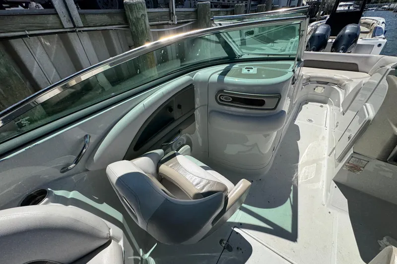 Slide: The Image of 2013 Crownline Eclipse E6 XS boat interior with seating and helm, docked by wooden pier. - 11