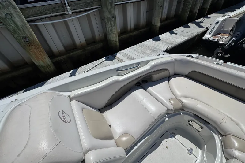 Slide: The Image of 2013 Crownline Eclipse E6 XS boat interior with white and beige seating at dock. - 19