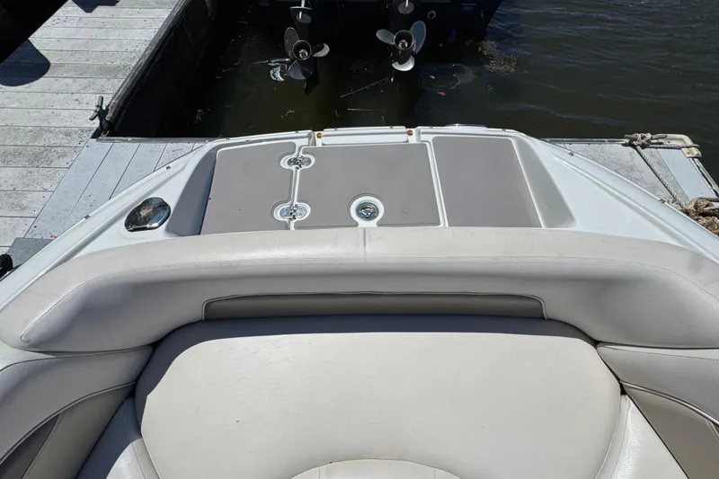Slide: The Image of 2013 Crownline Eclipse E6 XS boat interior, featuring cushioned seating and swim platform by the dock. - 21