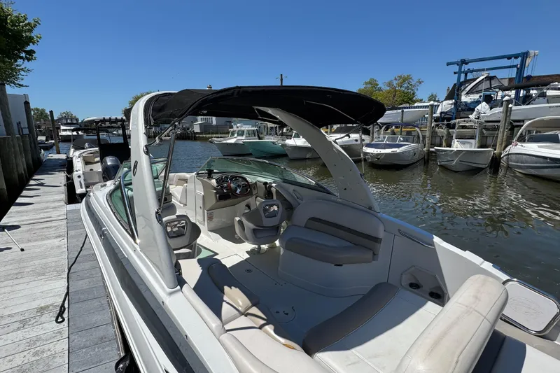 Slide: The Image of 2013 Crownline Eclipse E6 XS boat docked at marina, featuring spacious seating and sleek design. - 5
