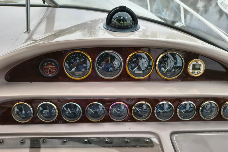 Slide: The Image of Dashboard of a 2001 Regal Commodore 3260 boat with various gauges and a compass. - 14