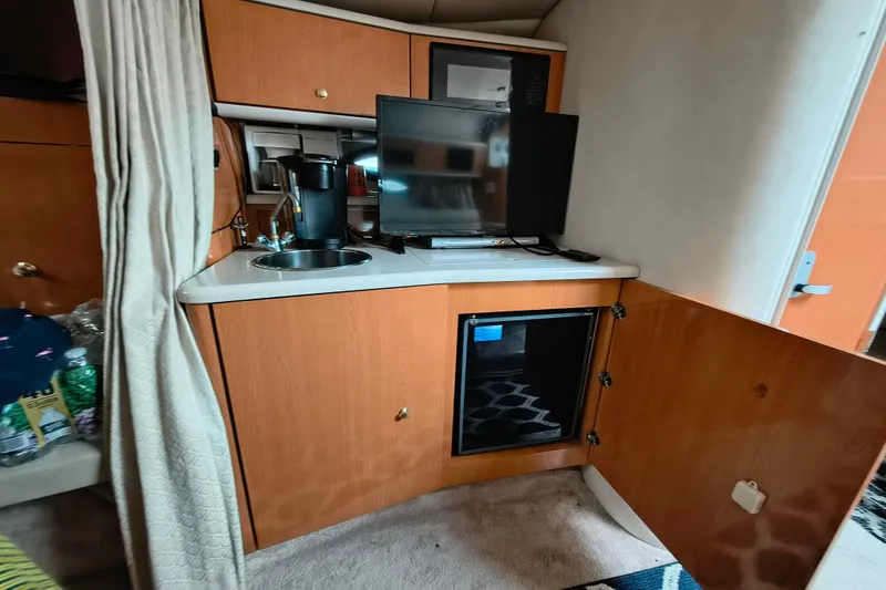 Slide: The Image of Interior of 2001 Regal Commodore 3260 yacht with kitchenette and TV. - 18