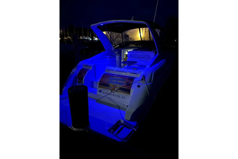 Slide: The Image of Regal Commodore 3260 boat at night with blue lighting. - 23