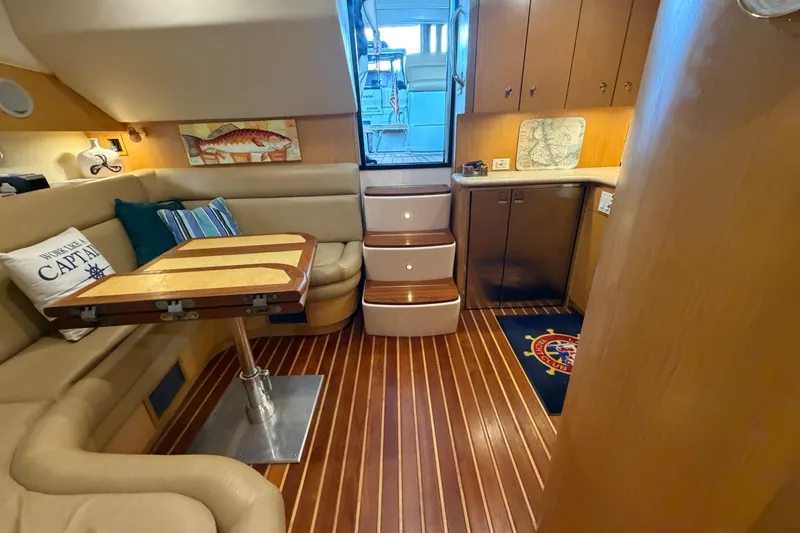 Slide: The Image of 2002 Tiara Yachts 3800 Open interior with cozy seating, wooden table, and nautical decor. - 25