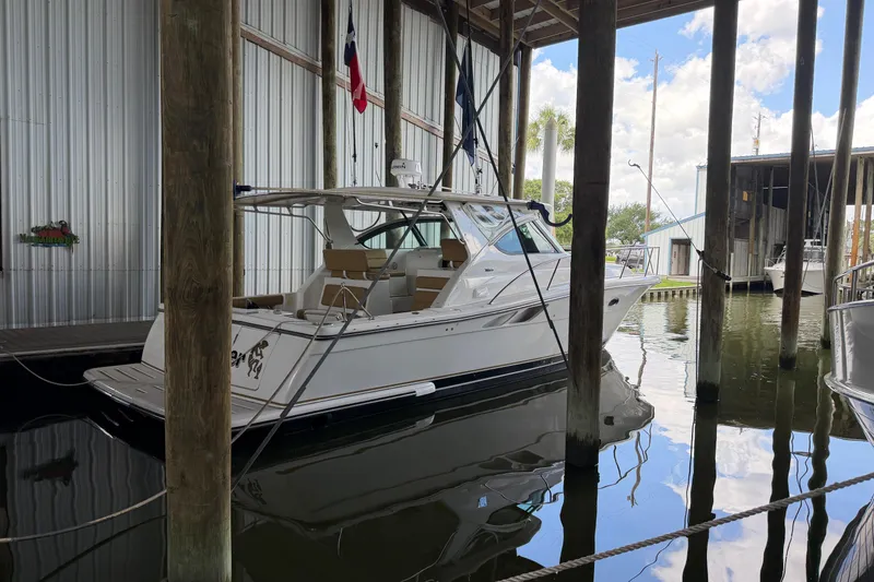 Slide: The Image of 2002 Tiara Yachts 3800 Open docked in a covered marina, reflecting on calm water. - 36