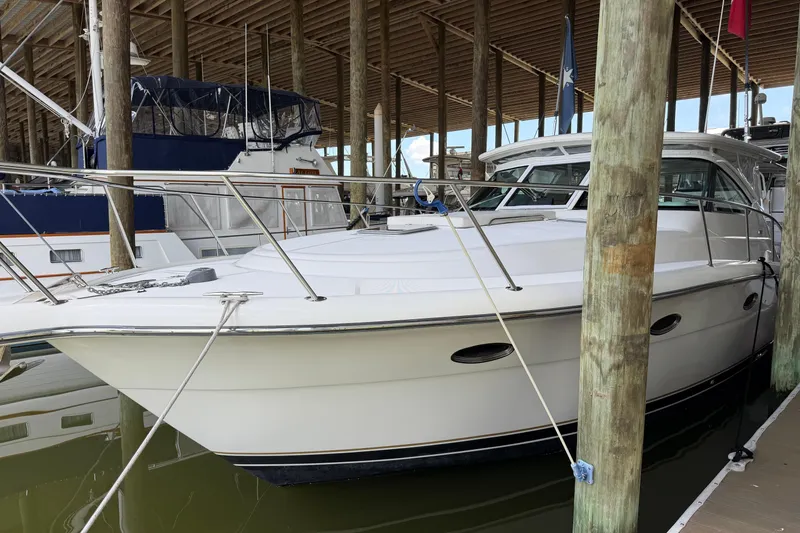 Slide: The Image of 2002 Tiara Yachts 3800 Open docked in a marina under a wooden canopy. - 4