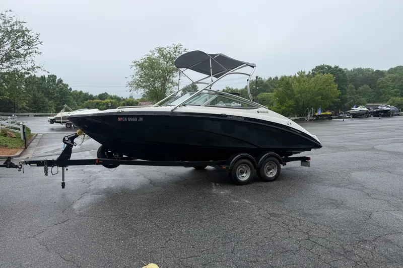 Slide: The Image of 2013 Yamaha AR210 boat on trailer in parking lot, overcast day. - 0