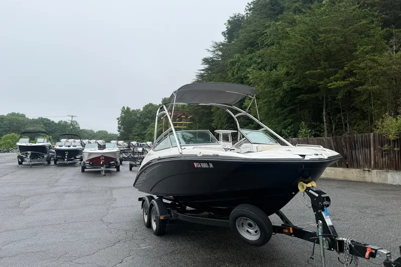 Slide: The Image of 2013 Yamaha AR210 boat on trailer, surrounded by other boats, in a parking area. - 3