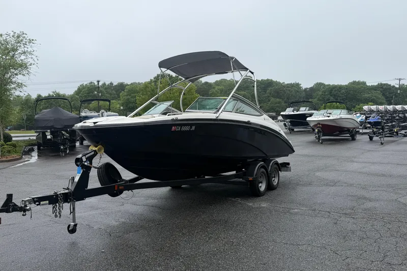 Slide: The Image of 2013 Yamaha Boats AR210 on trailer in parking lot, surrounded by other boats. - 4