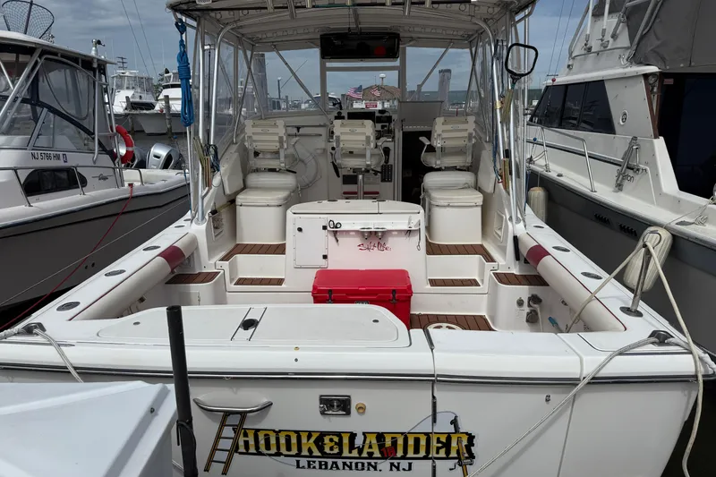 Slide: The Image of 2001 Pursuit 3000 Offshore boat docked, featuring spacious deck and seating area. - 1