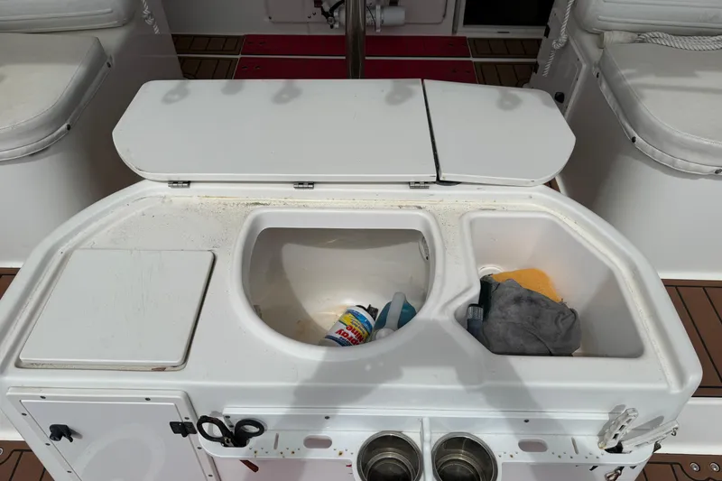 Slide: The Image of 2001 Pursuit 3000 Offshore boat sink with cleaning supplies and storage compartments. - 10