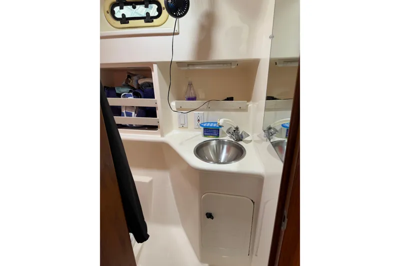 Slide: The Image of 2001 Pursuit 3000 Offshore boat interior with sink, storage, and mirror. - 24