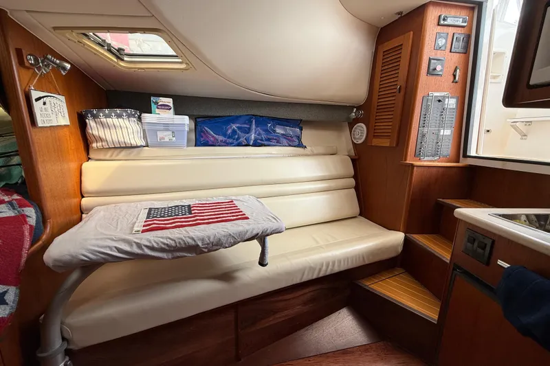 Slide: The Image of Interior of a 2001 Pursuit 3000 Offshore boat with seating and American flag decor. - 25