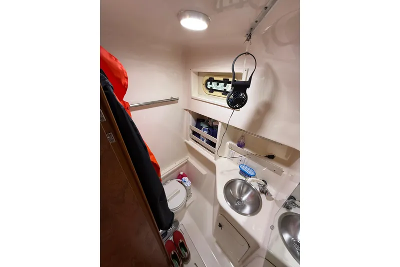 Slide: The Image of Compact bathroom in 2001 Pursuit 3000 Offshore boat with sink, toilet, and storage. - 27