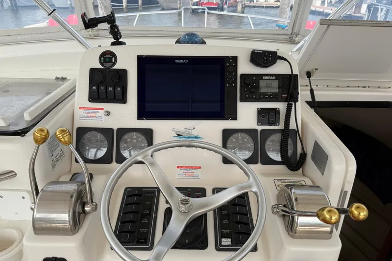 Slide: The Image of Control panel of a 2001 Pursuit 3000 Offshore boat with steering wheel and navigation instruments. - 28