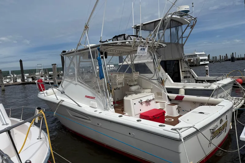 Slide: The Image of 2001 Pursuit 3000 Offshore boat docked at marina under clear sky. - 3