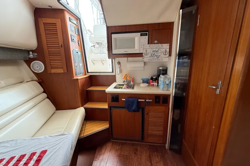 Slide: The Image of Interior of a 2001 Pursuit 3000 Offshore boat with kitchenette and seating area. - 30