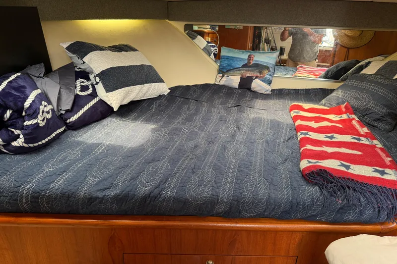 Slide: The Image of Cozy cabin interior of 2001 Pursuit 3000 Offshore with nautical-themed bedding. - 31