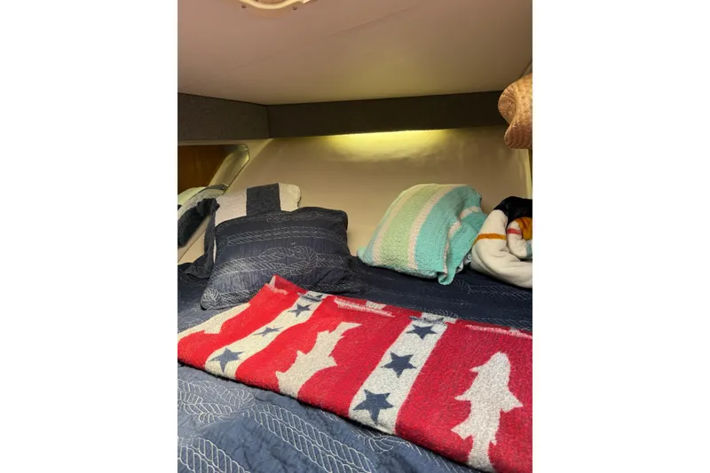 Slide: The Image of Cozy cabin interior of 2001 Pursuit 3000 Offshore with colorful blankets and pillows. - 33