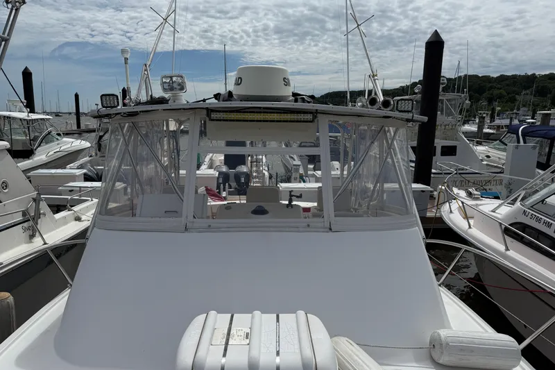 Slide: The Image of 2001 Pursuit 3000 Offshore boat docked at marina under cloudy sky. - 4