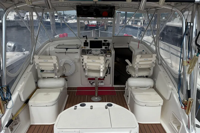 Slide: The Image of 2001 Pursuit 3000 Offshore boat interior with helm, seating, and marina view. - 5