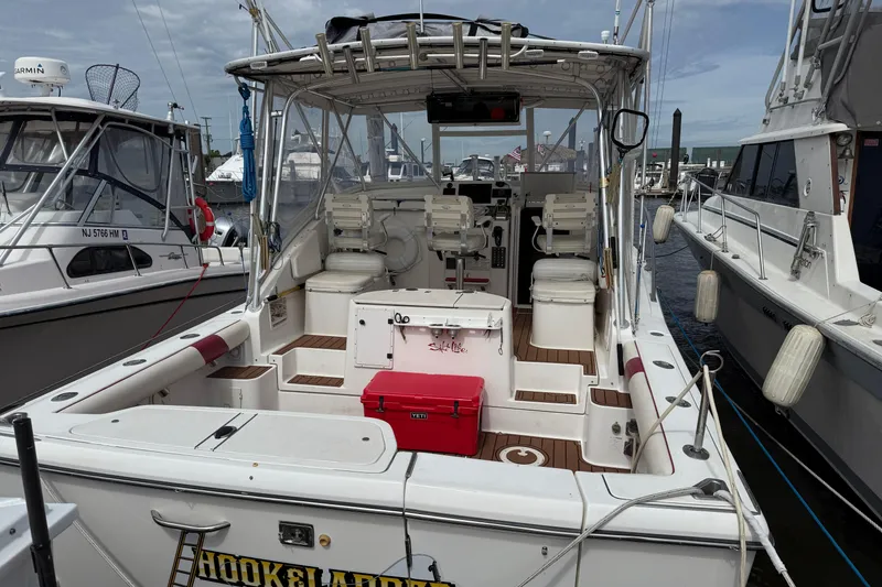 Slide: The Image of 2001 Pursuit 3000 Offshore boat docked, featuring spacious cockpit and fishing equipment. - 7