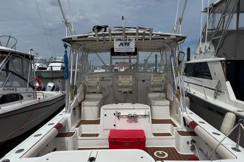 Slide: The Image of 2001 Pursuit 3000 Offshore boat docked, featuring spacious deck and seating area. - 8