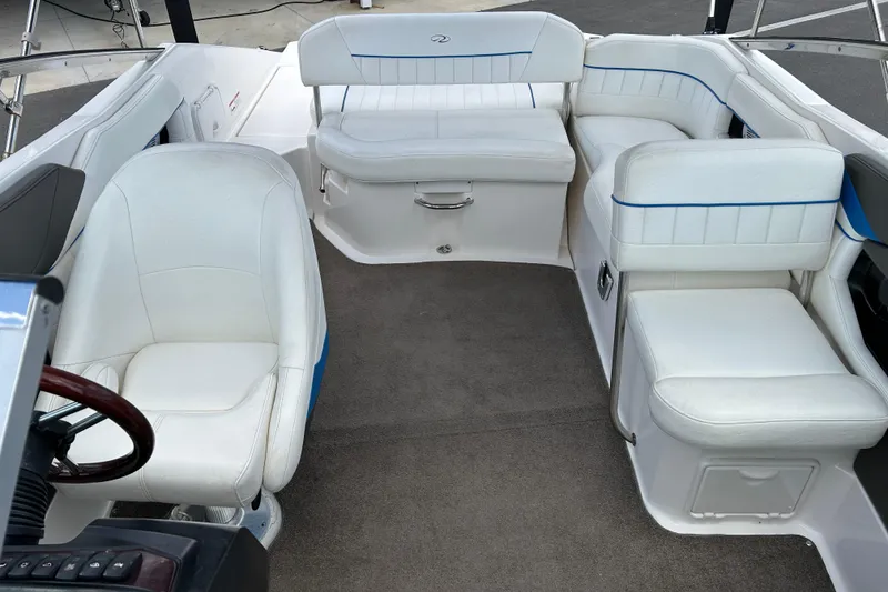 Slide: The Image of Interior of a 2008 Regal 2520 FasDeck boat with white seating and carpeted floor. - 12