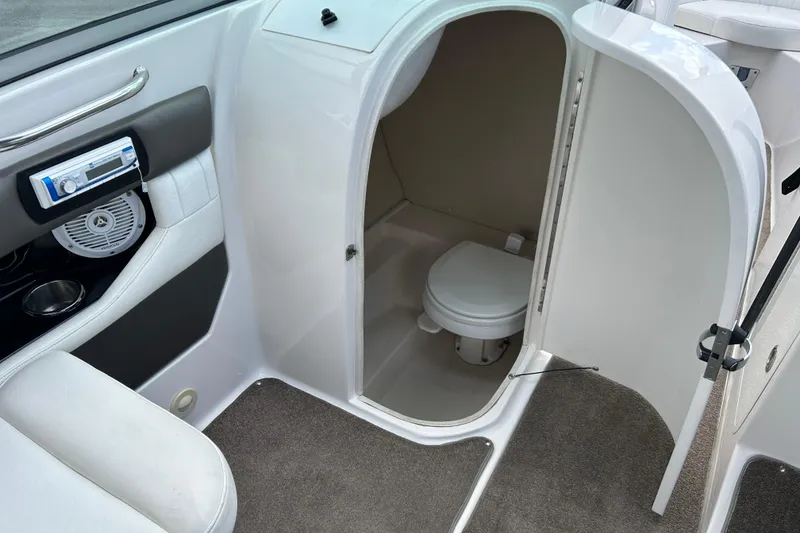 Slide: The Image of Interior of a 2008 Regal 2520 FasDeck boat featuring a compact marine toilet. - 16