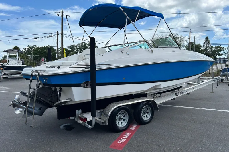 Slide: The Image of 2008 Regal 2520 FasDeck boat with blue hull on a trailer, parked outdoors. - 2