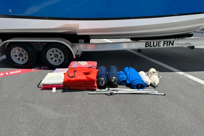 Slide: The Image of Trailer with Regal 2520 FasDeck boat, 2008 model, and boating gear on pavement. - 20