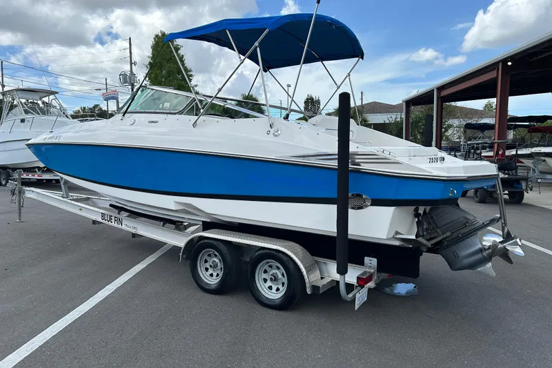Slide: The Image of 2008 Regal 2520 FasDeck boat with blue hull on trailer, parked outdoors. - 4