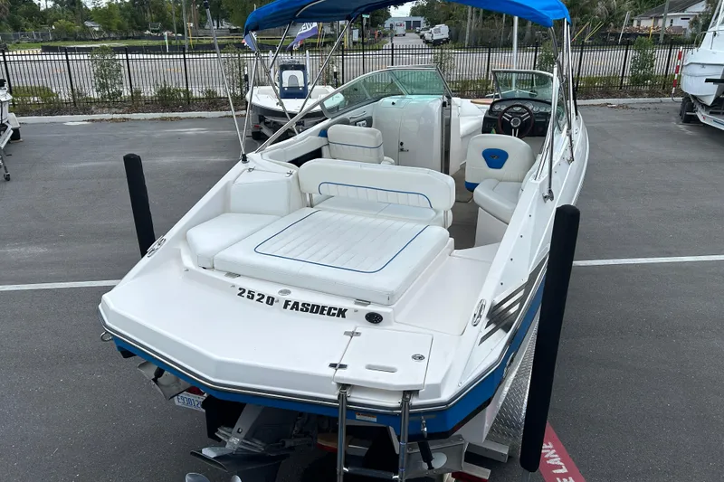 Slide: The Image of 2008 Regal 2520 FasDeck boat with blue canopy, parked in a marina. - 7