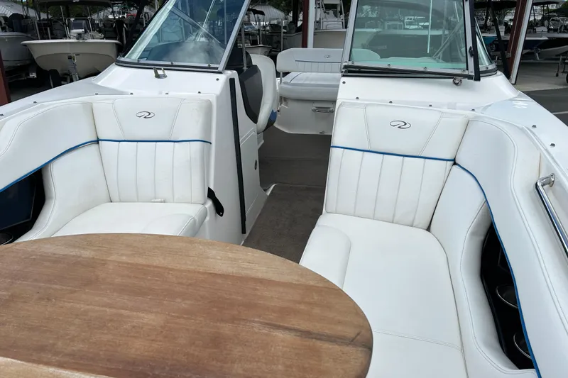 Slide: The Image of Interior of a 2008 Regal 2520 FasDeck boat with white seating and wooden table. - 9